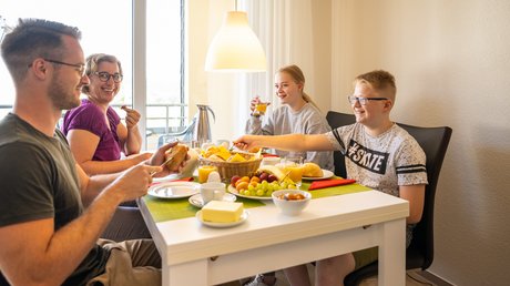 Ferien in der Eifel: ein erster Einblick Familie sitzt am Tisch und frühstückt gemeinsam mit Saft und Brot