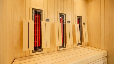Ferien in der Eifel: ein erster Einblick Infrarotkabine mit Holzbank und Heizstrahlern an der Holzwand