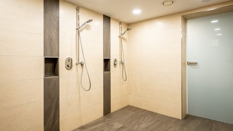 Ferien in der Eifel: ein erster Einblick Moderne Duschen mit Handbrausen und Fliesen in neutralen Farben