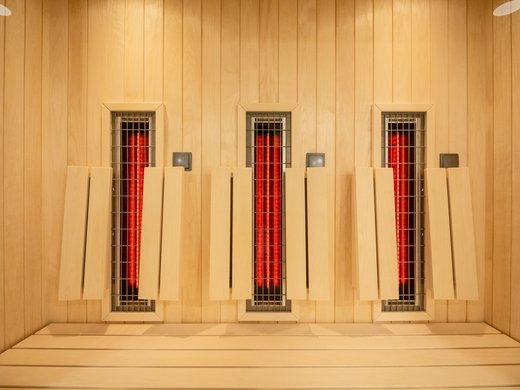 Eine Ferienwohnung in der Eifel mit Sauna und Gym Infrarot-Heizelemente an einer Holzsaunawand mit Holzbänken