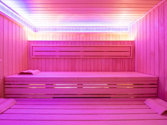 Ferienwohnungen in Gemünd mit dem gewissen Extra Moderne Sauna mit rosa Beleuchtung und Holzliegen mit Kopfstützen