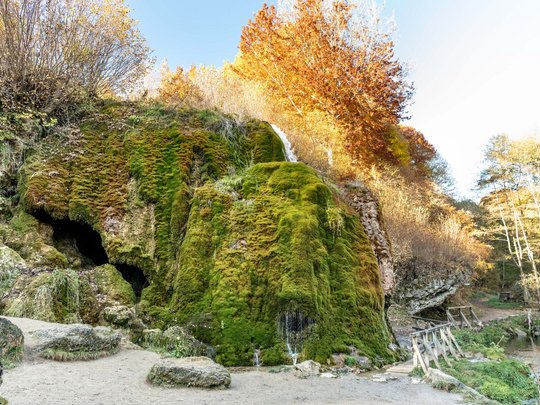 Ferienwohnungen in Gemünd mit dem gewissen Extra Moosbedeckter Felsen mit kleinem Wasserfall und Herbstbäumen
