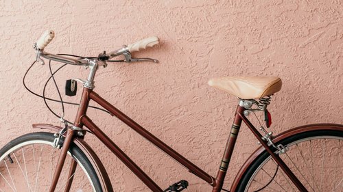 Ferienwohnungen in Gemünd mit dem gewissen Extra Rotes Vintage-Fahrrad vor texturierter rosa Wand